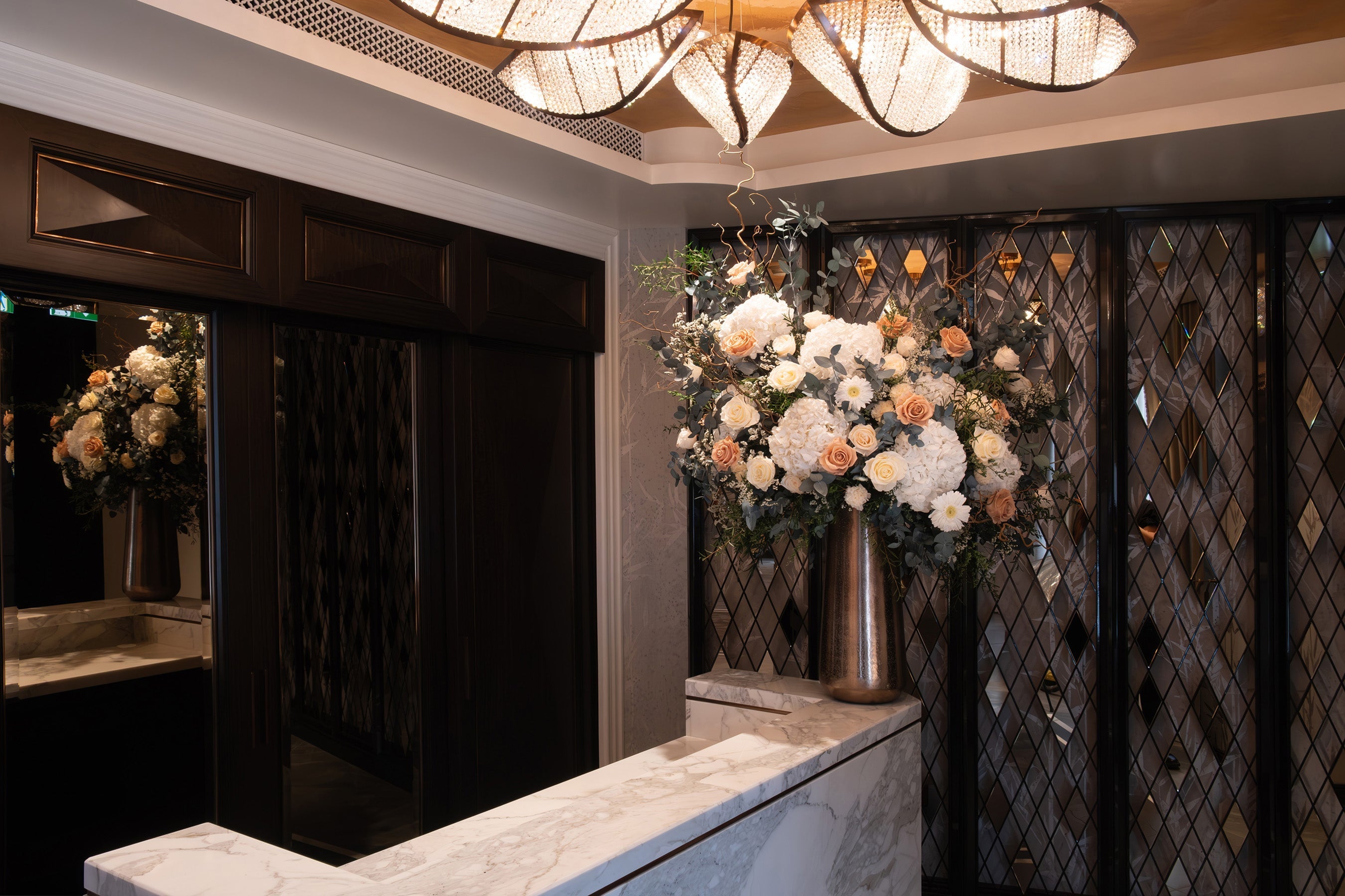 Preserved toffee mix flowers asymmetrical arrangement in hotel lobby