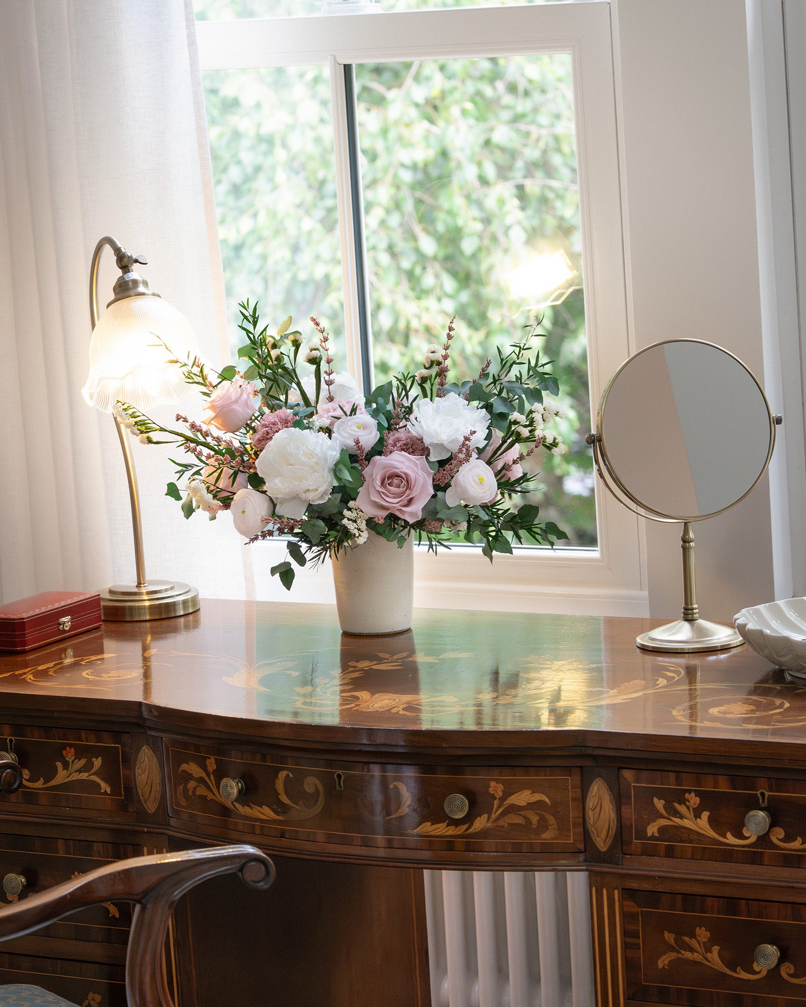 Willow preserved mixed flower arrangement in ceramic vase on desk