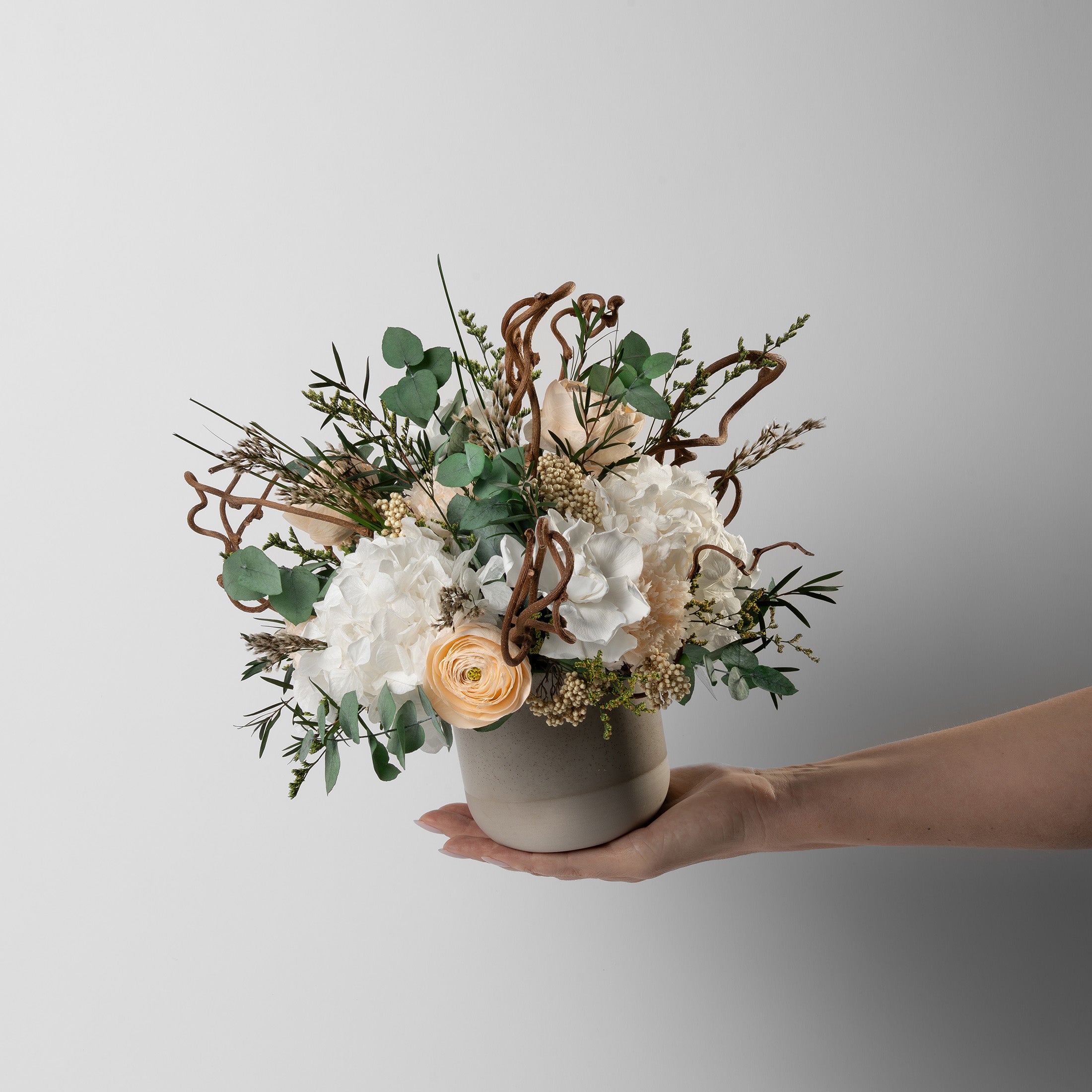 PRESERVED WHITE AND PEACH WILD MIXED FLOWER ARRANGEMENT IN STONE VASE