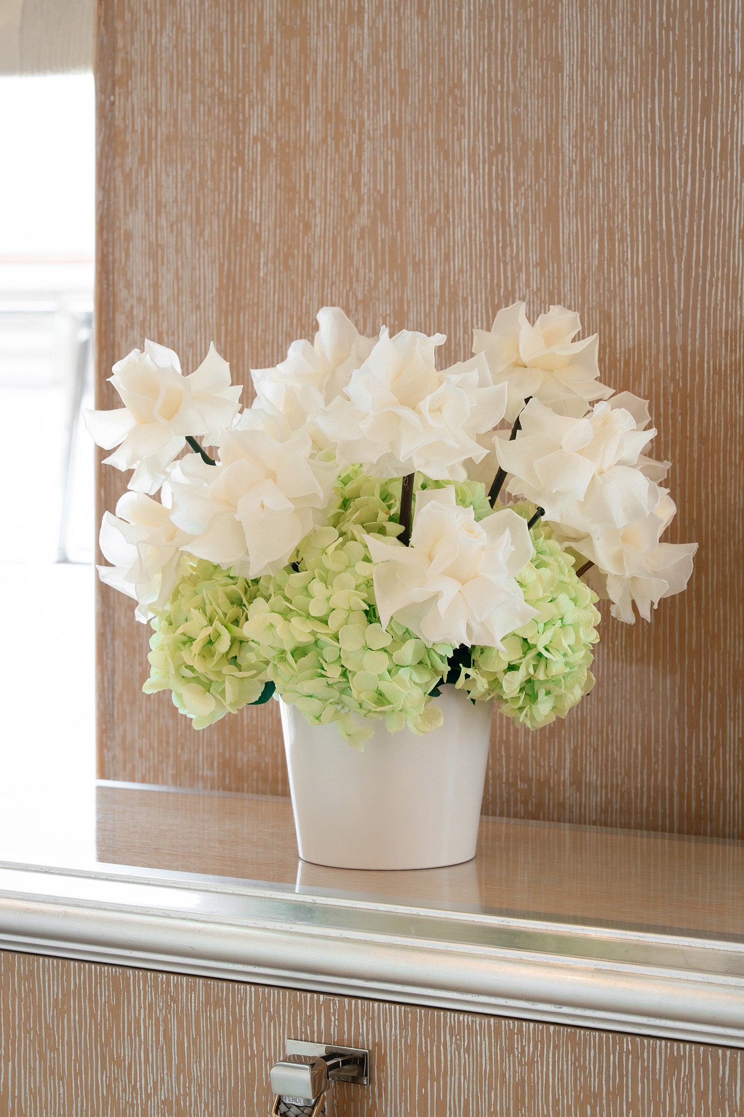 Long lasting preserved arrangement with preserved roses and hydrangeas in a white vase on board a yacht