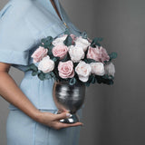 A preserved blush rose dome with foliage in silver vase