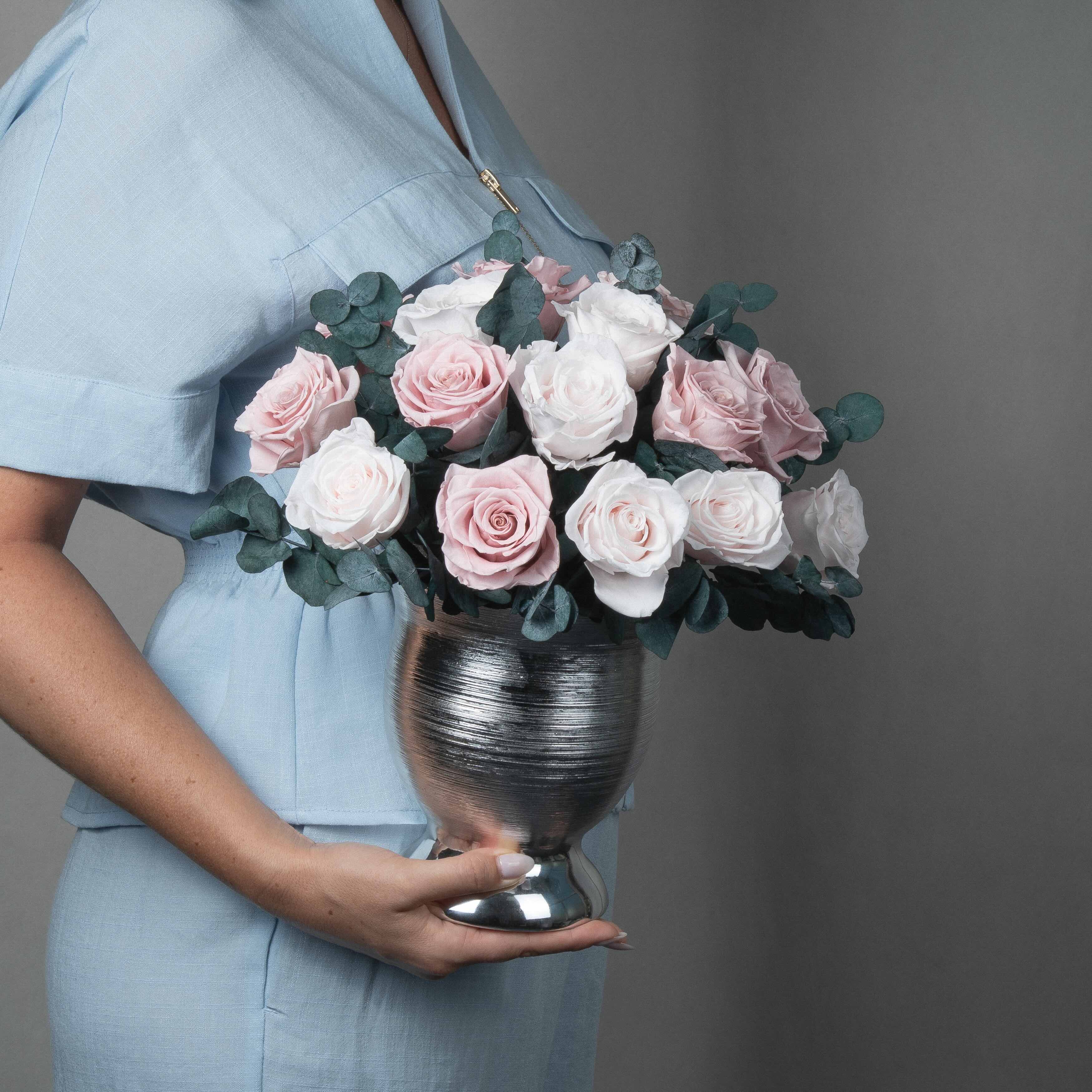 A preserved blush rose dome with foliage in silver vase