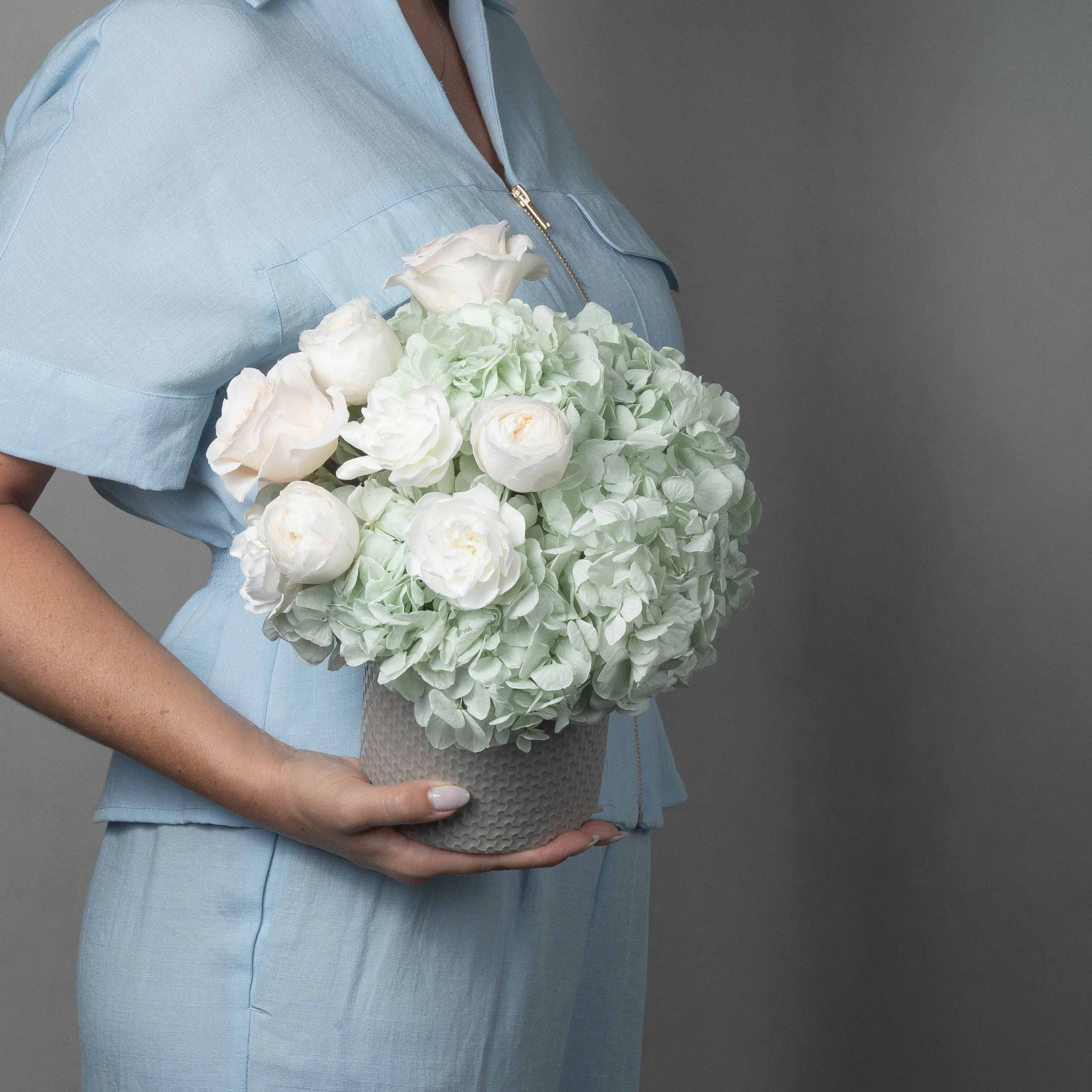 A preserved green hydrangea, gardenia and rose arrangement