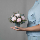 A preserved pink rose arrangement in green vase