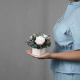 A preserved blush rose arrangement in marble vase