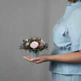 A small preserved pink rose arrangement with preserved foliage