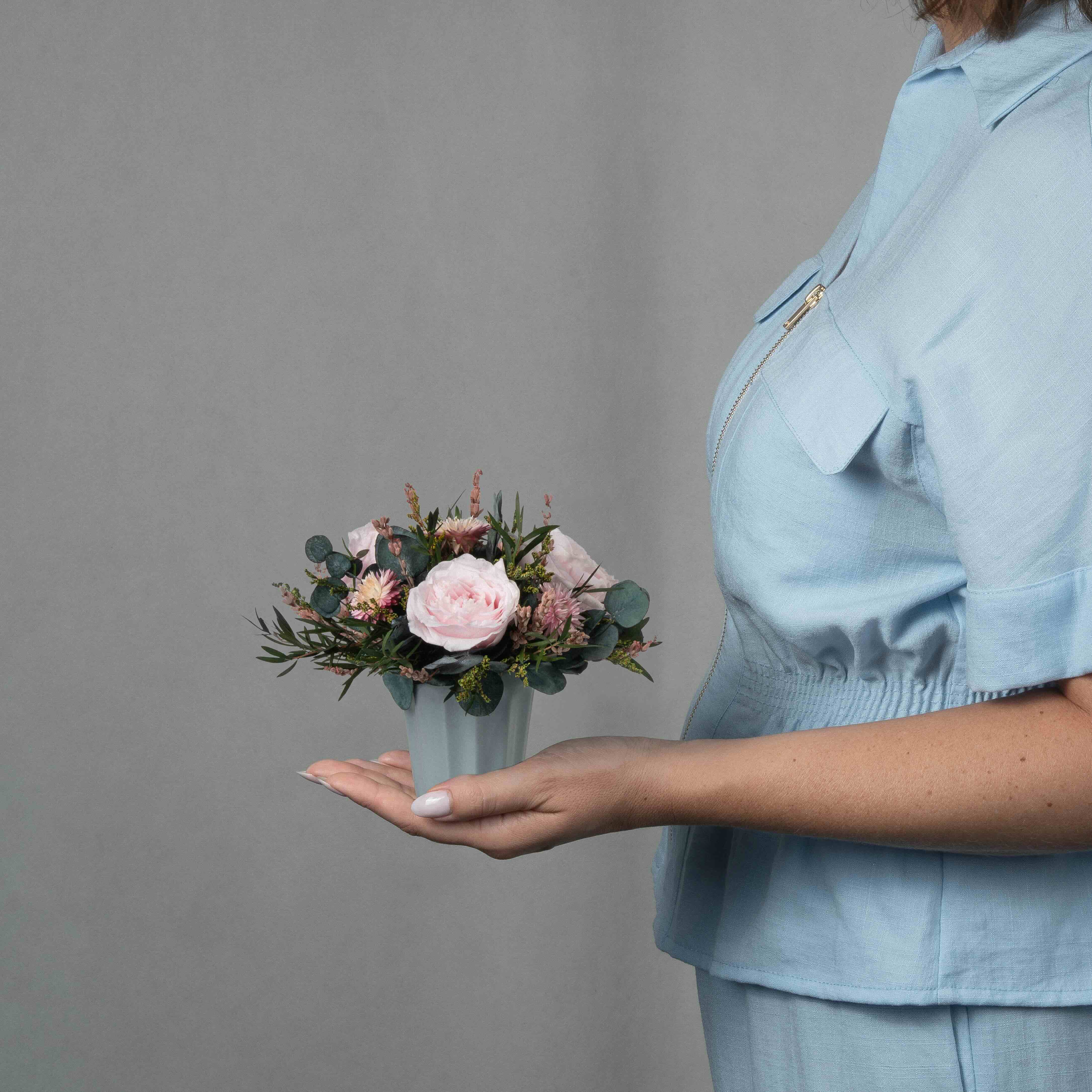 A small preserved pink rose arrangement with preserved foliage