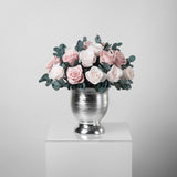A preserved blush rose dome with foliage in silver vase