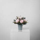 A preserved pink rose arrangement in green vase