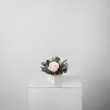 A preserved blush rose arrangement in marble vase
