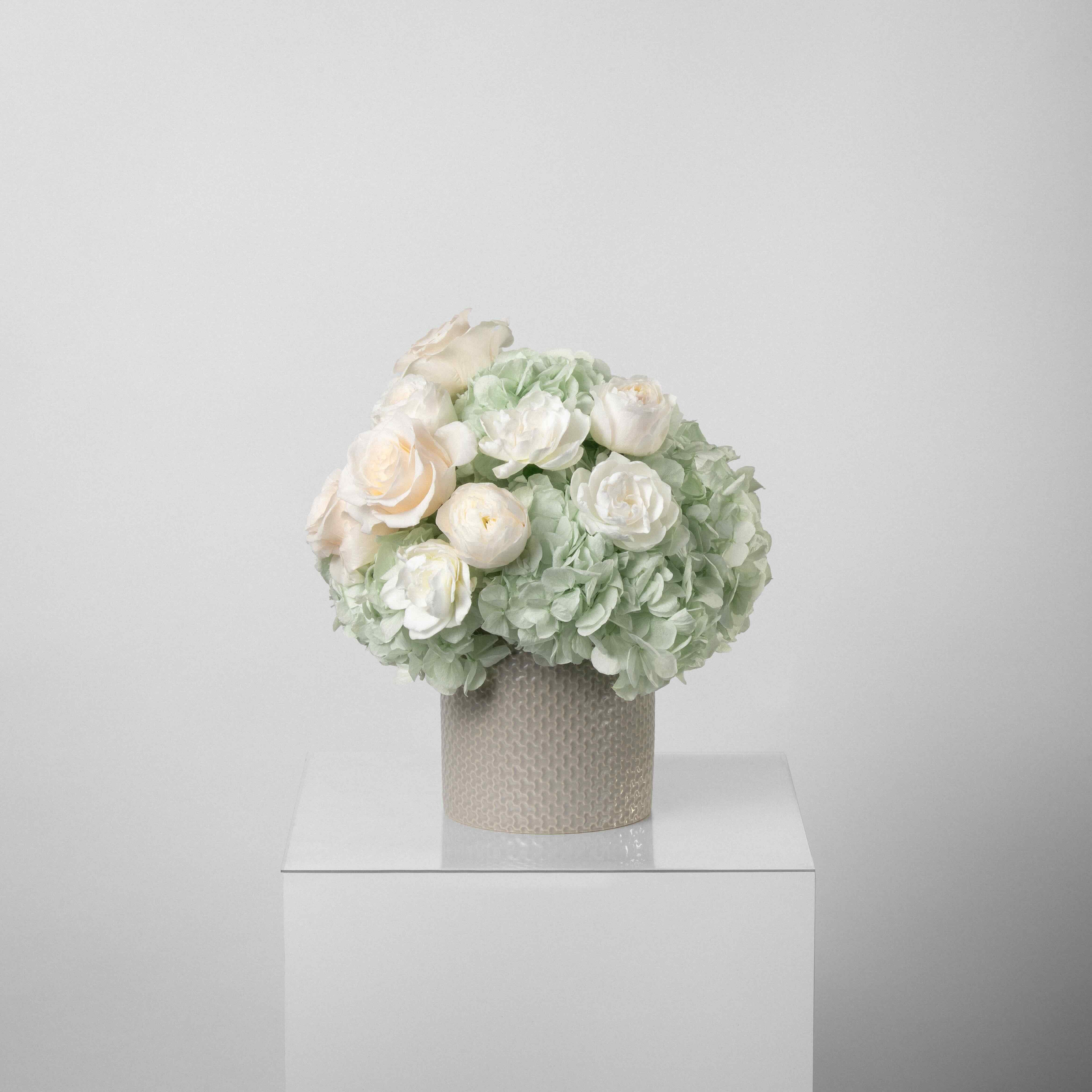 A preserved green hydrangea, gardenia and rose arrangement