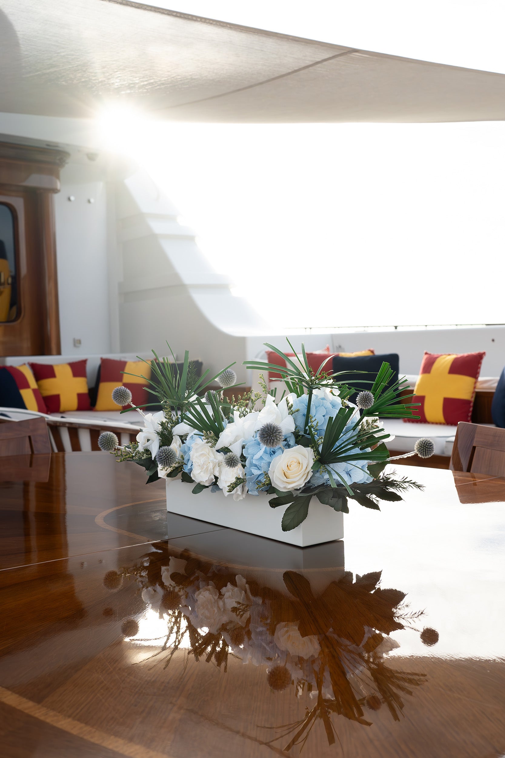 Preserved mixed flowers arrangement in a long low vase on sun deck