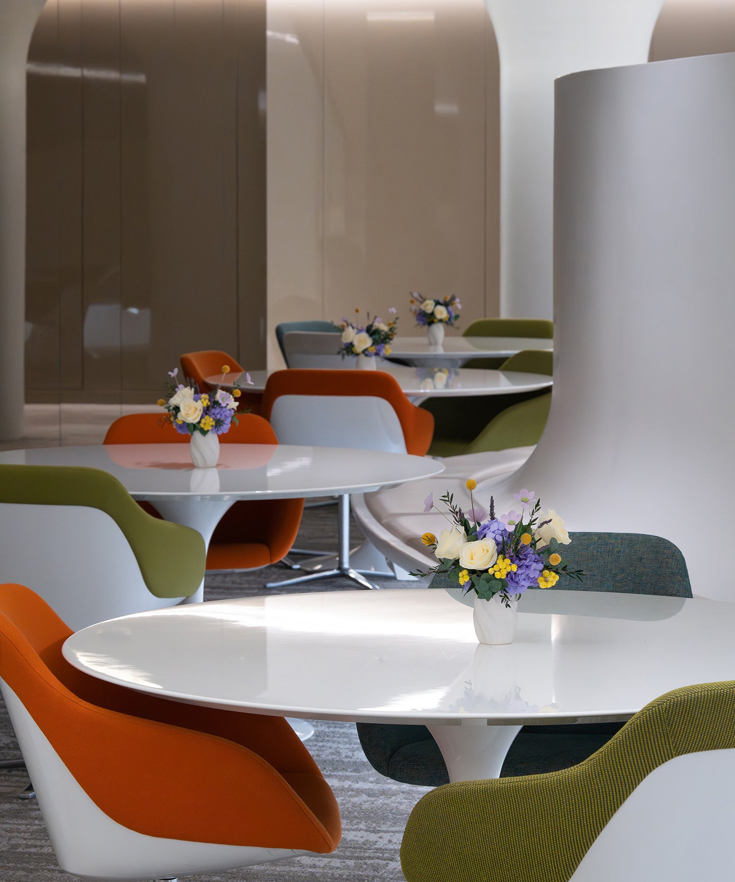 Preserved roses and hydrangeas in lilac and yellow colour on office tables

