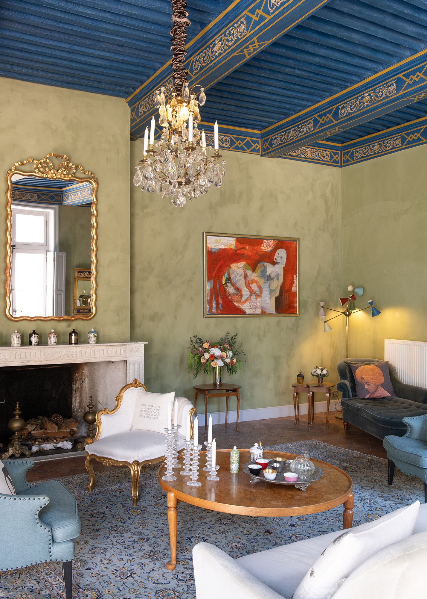Luxurious living room with ornate ceiling, fireplace, and preserved mixed flower arrangement.
