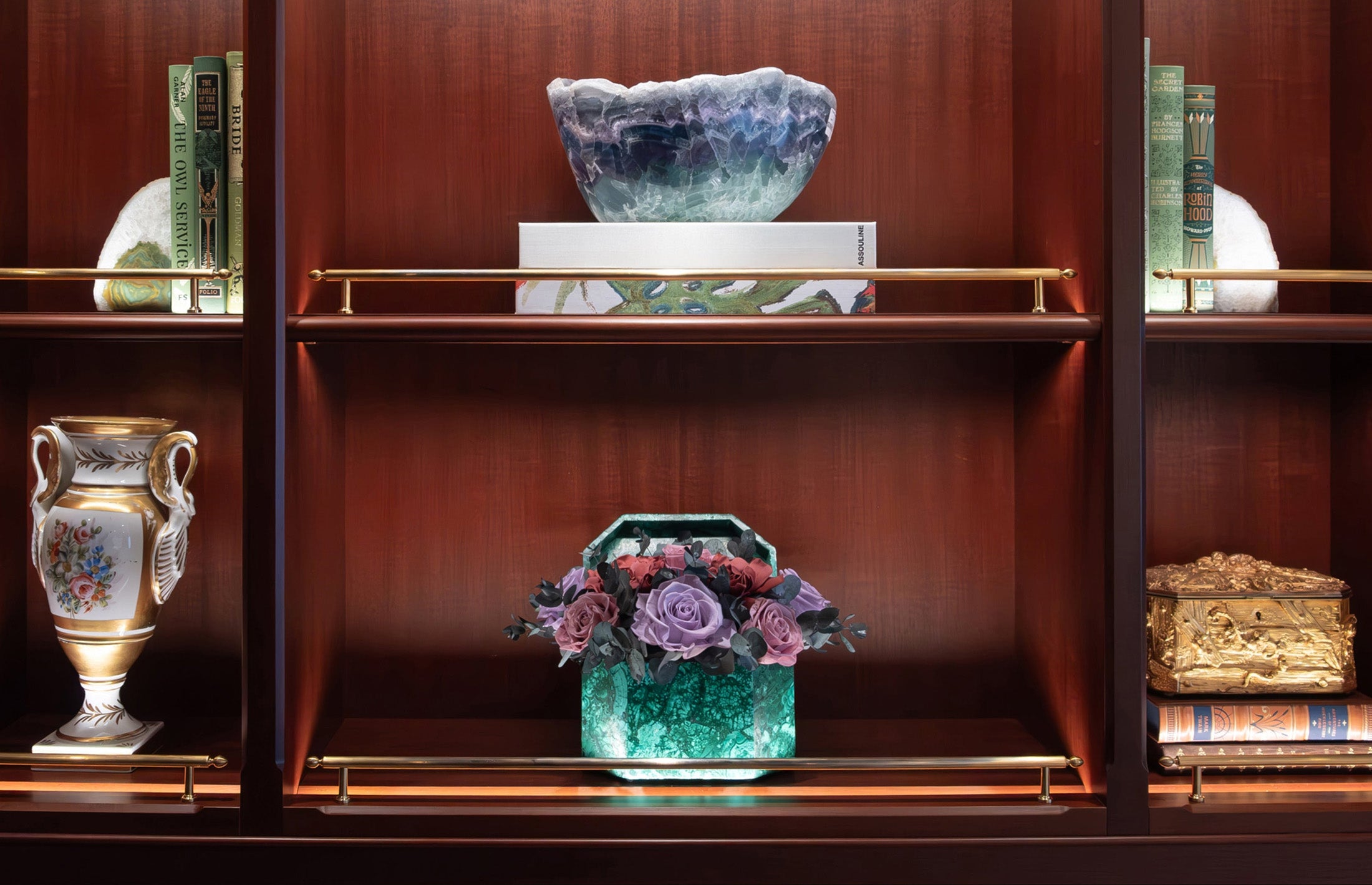 Decorative shelf with a preserved rose and gardenia arrangement in vase, against a wooden background