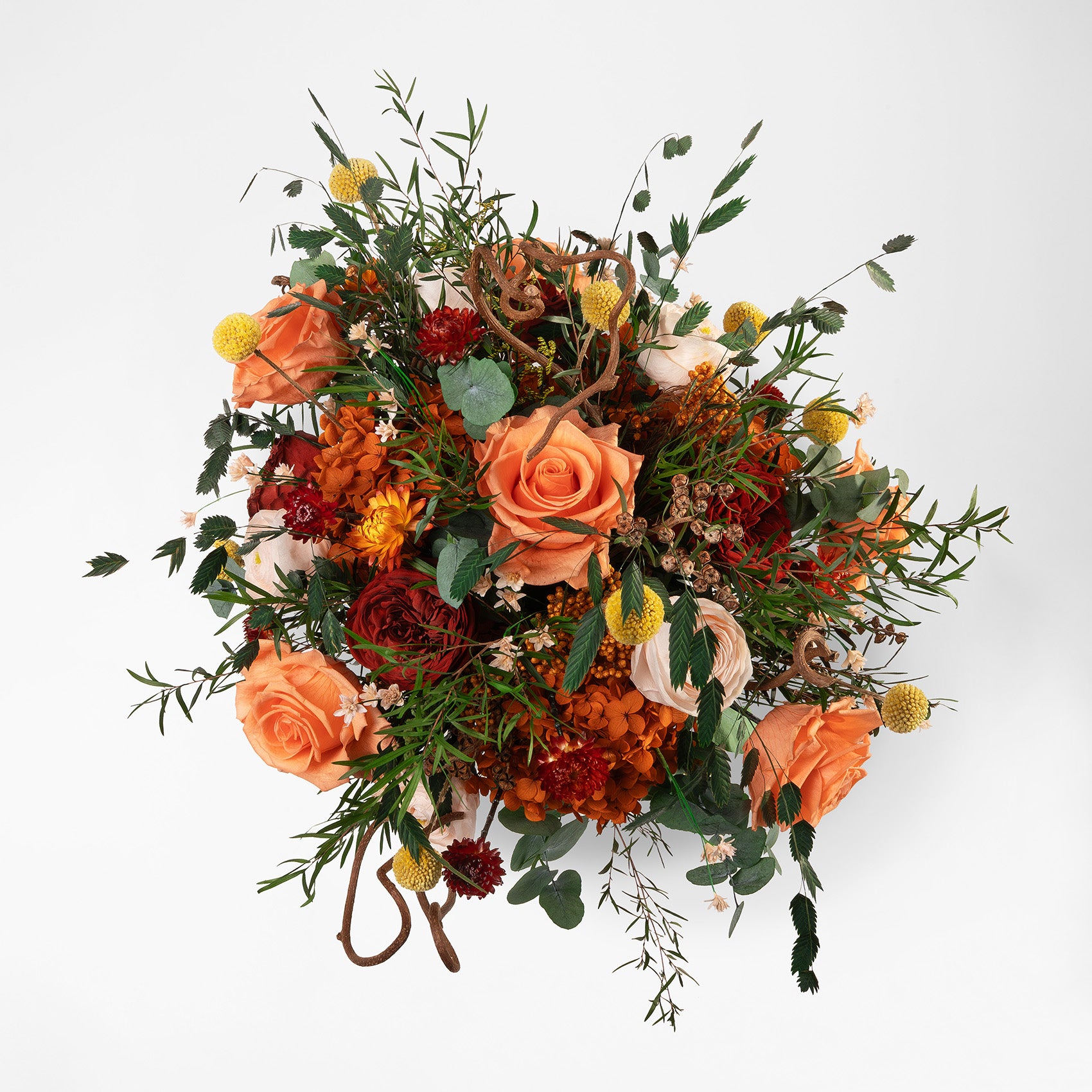 Preserved floral arrangement with orange, red, peach, and filler flowers in a ceramic handmade vase 