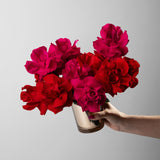 Preserved red and hot pink reflexed roses in a gold glass vase
