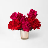 Preserved red and hot pink reflexed roses in a gold glass vase