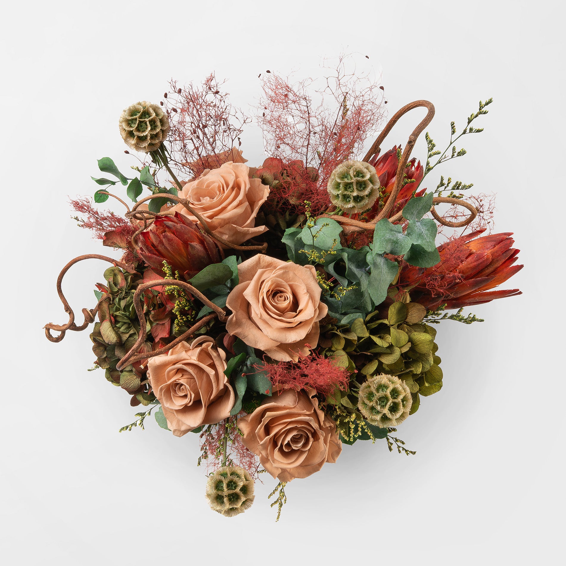 Bouquet of toffee and green mix preserved flowers in a ceramic vase on a white background