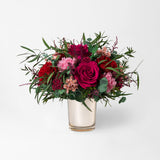 Preserved bouquet of red and pink flowers in a gold glass vase 