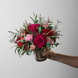 Preserved bouquet of red and pink flowers in a gold glass vase 