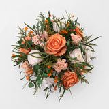 Preserved bouquet of orange and white flowers in a gold glass vase 