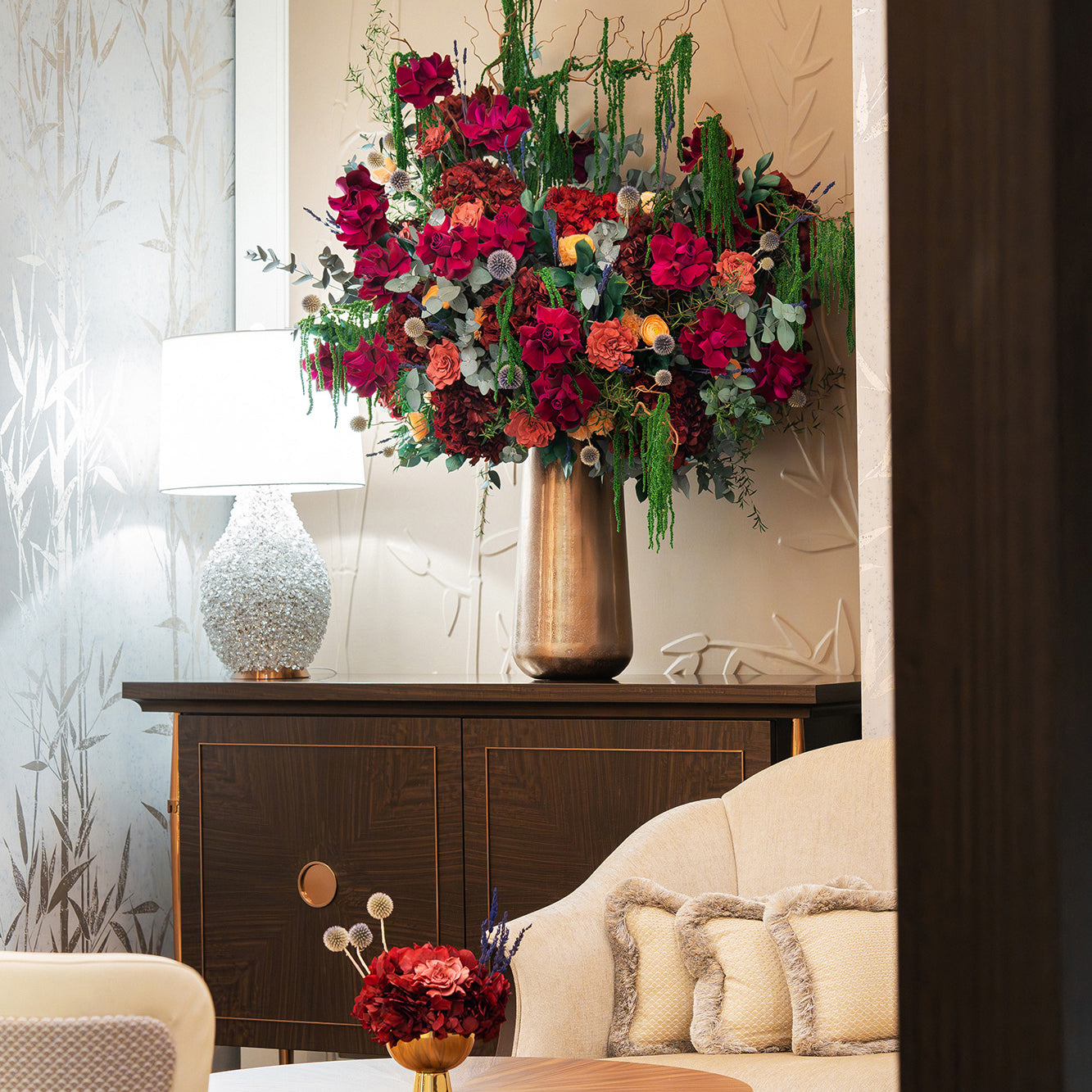 Large preserved mixed flower arrangement and a small preserved hydrangea bouquet in a bar lobby