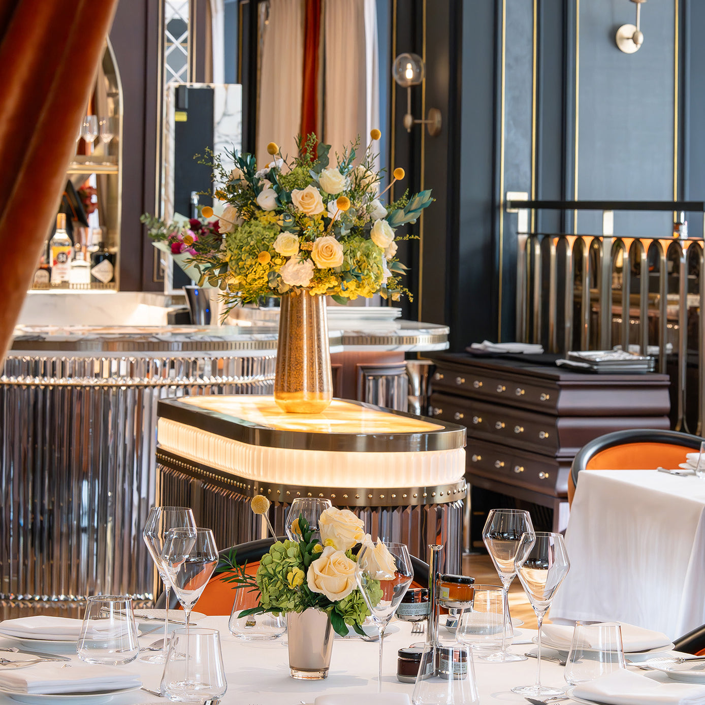Preserved green and cream floral arrangements in a hotel restaurant.