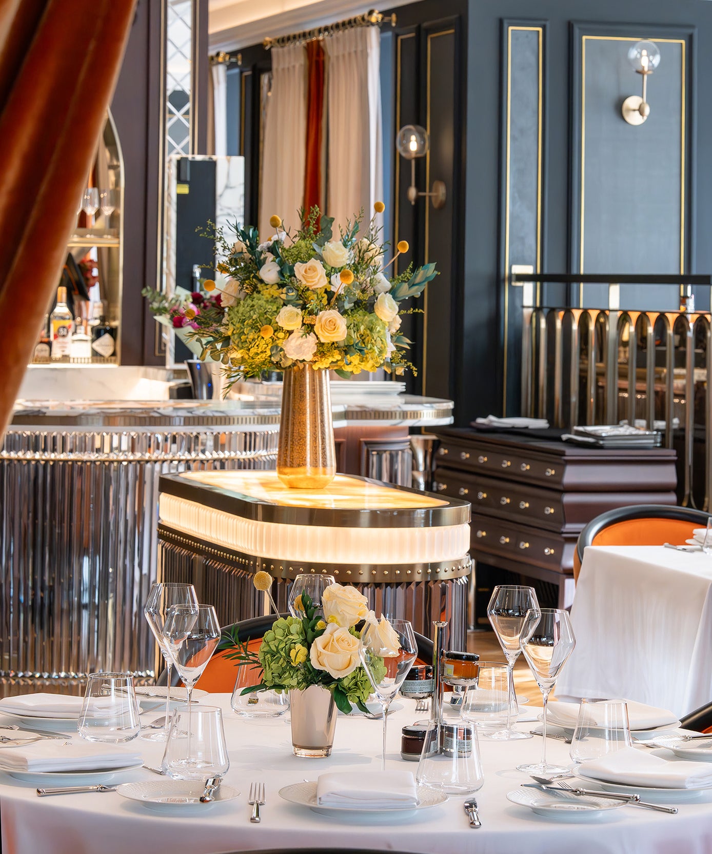 Preserved green and cream floral arrangements in a hotel restaurant.