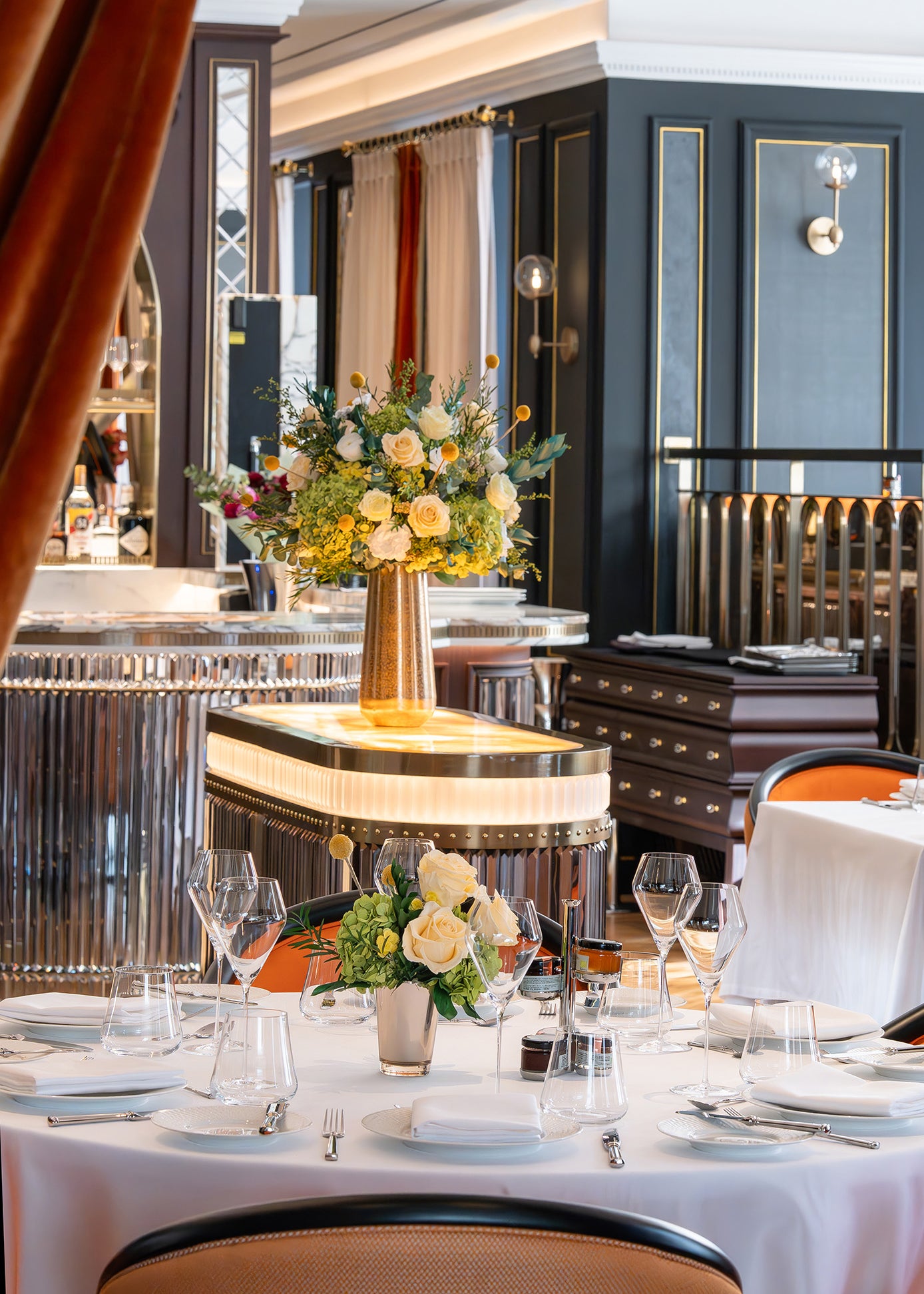 Preserved green and cream floral arrangements in a hotel restaurant.