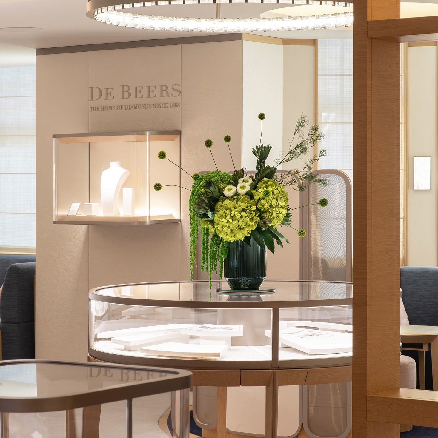 Preserved green hydrangea, chrysanthemum, scabiosa and amaranth arrangement displayed in a luxury store
