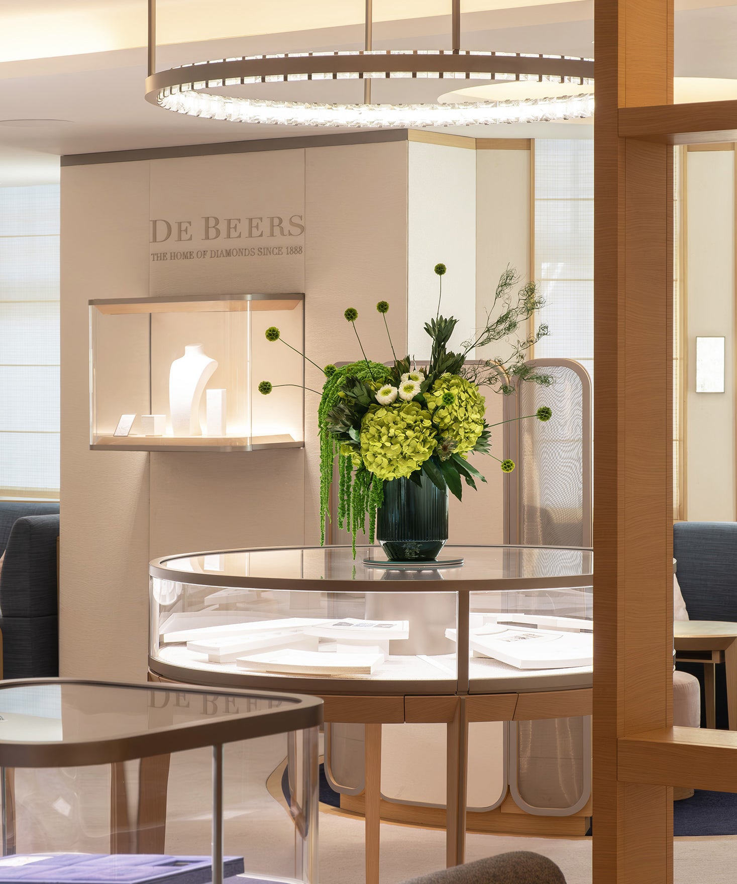 Preserved green hydrangea, chrysanthemum, scabiosa and amaranth arrangement displayed in a luxury store