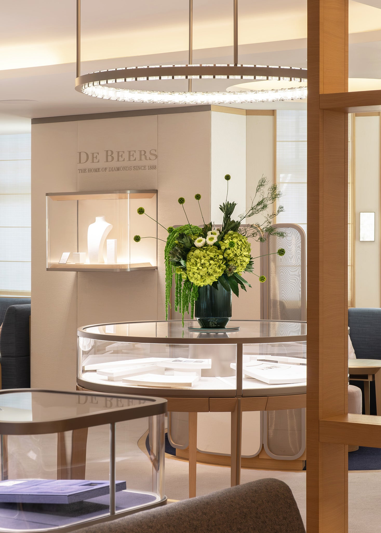 Preserved green hydrangea, chrysanthemum, scabiosa and amaranth arrangement displayed in a luxury store
