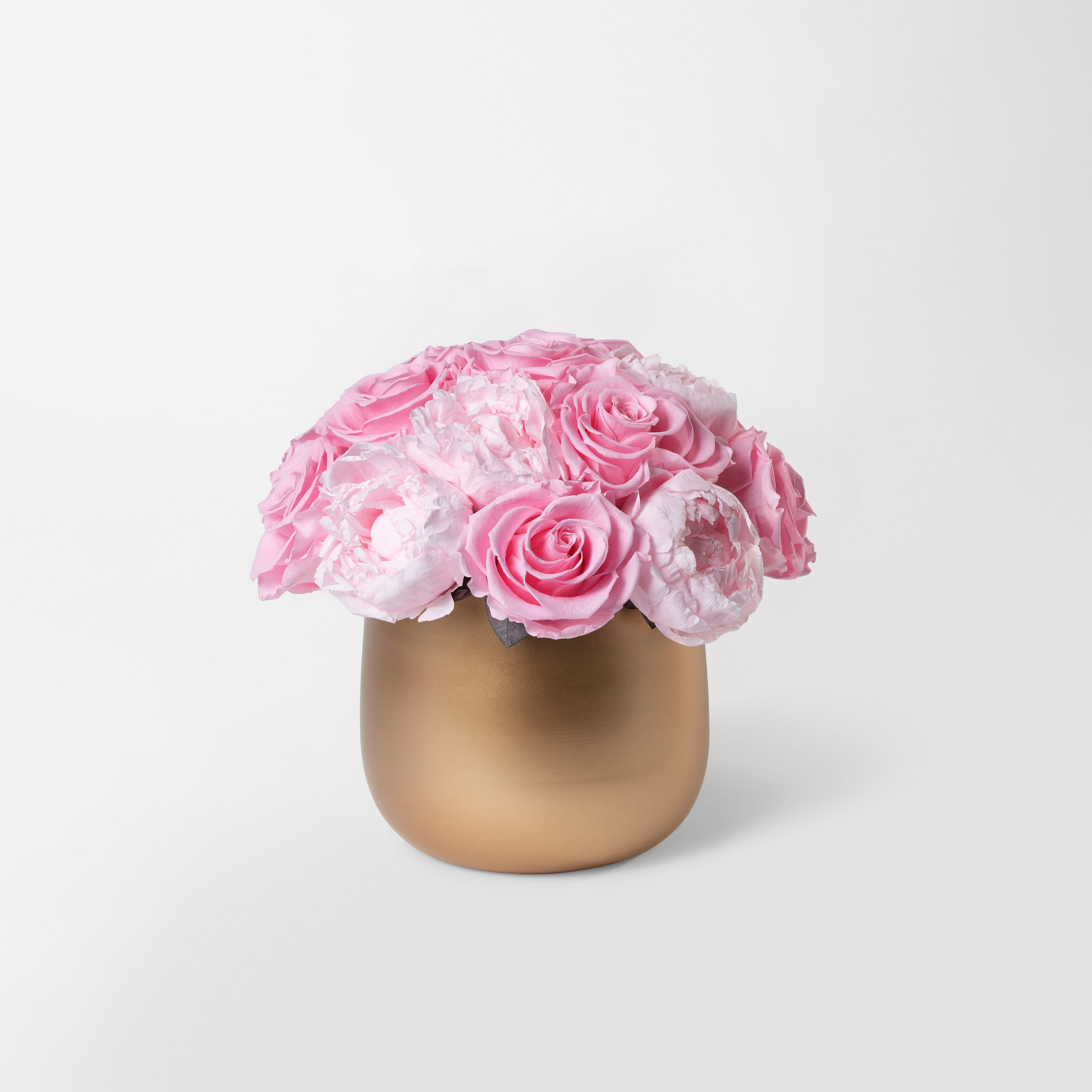 Gold vase with preserved pink roses and peonies