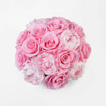 Gold vase with preserved pink roses and peonies