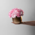 Gold vase with preserved pink roses and peonies