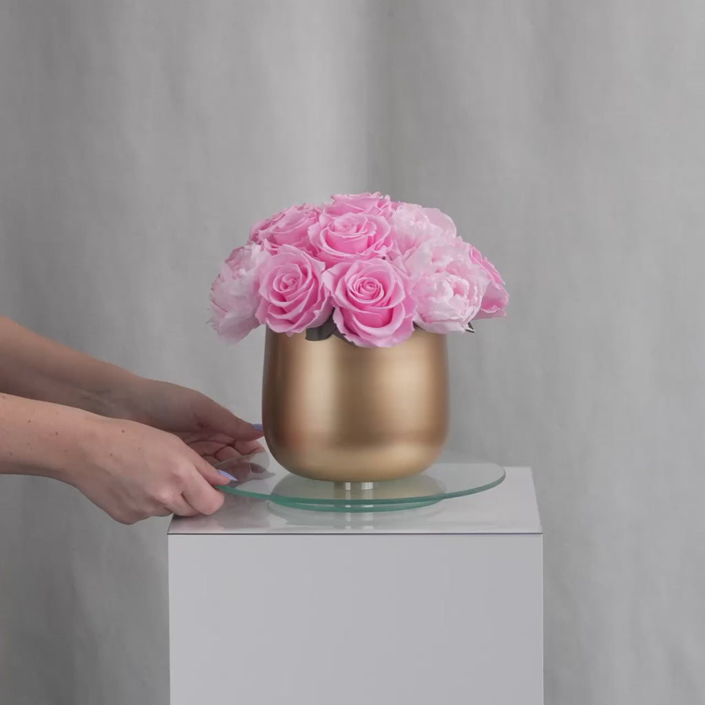 Gold vase with preserved pink roses and peonies