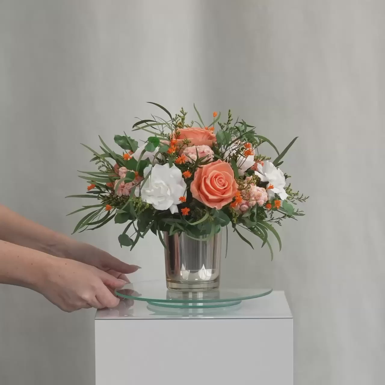 Preserved bouquet of orange and white flowers in a gold glass vase 